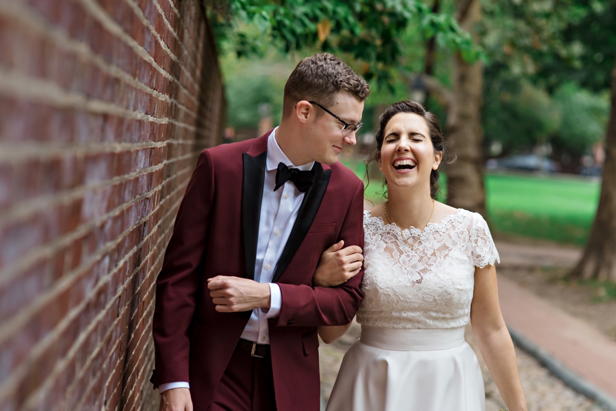 A groom makes his bride laugh as they walk the streets of Philadelphia.
